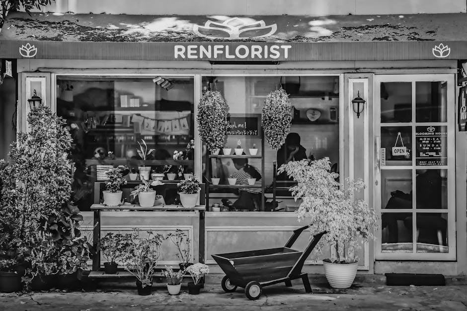 A black and white photograph of the exterior of a florist shop named Renflorist, located near St Mary Cray station. The shop has a large front window displaying various potted plants and floral arrang